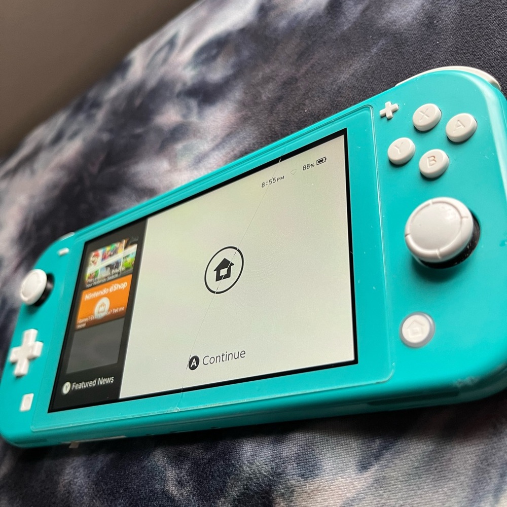 Turquoise Nintendo Switch Lite with a Black carrying bag